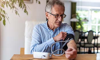 older man checking blood pressure